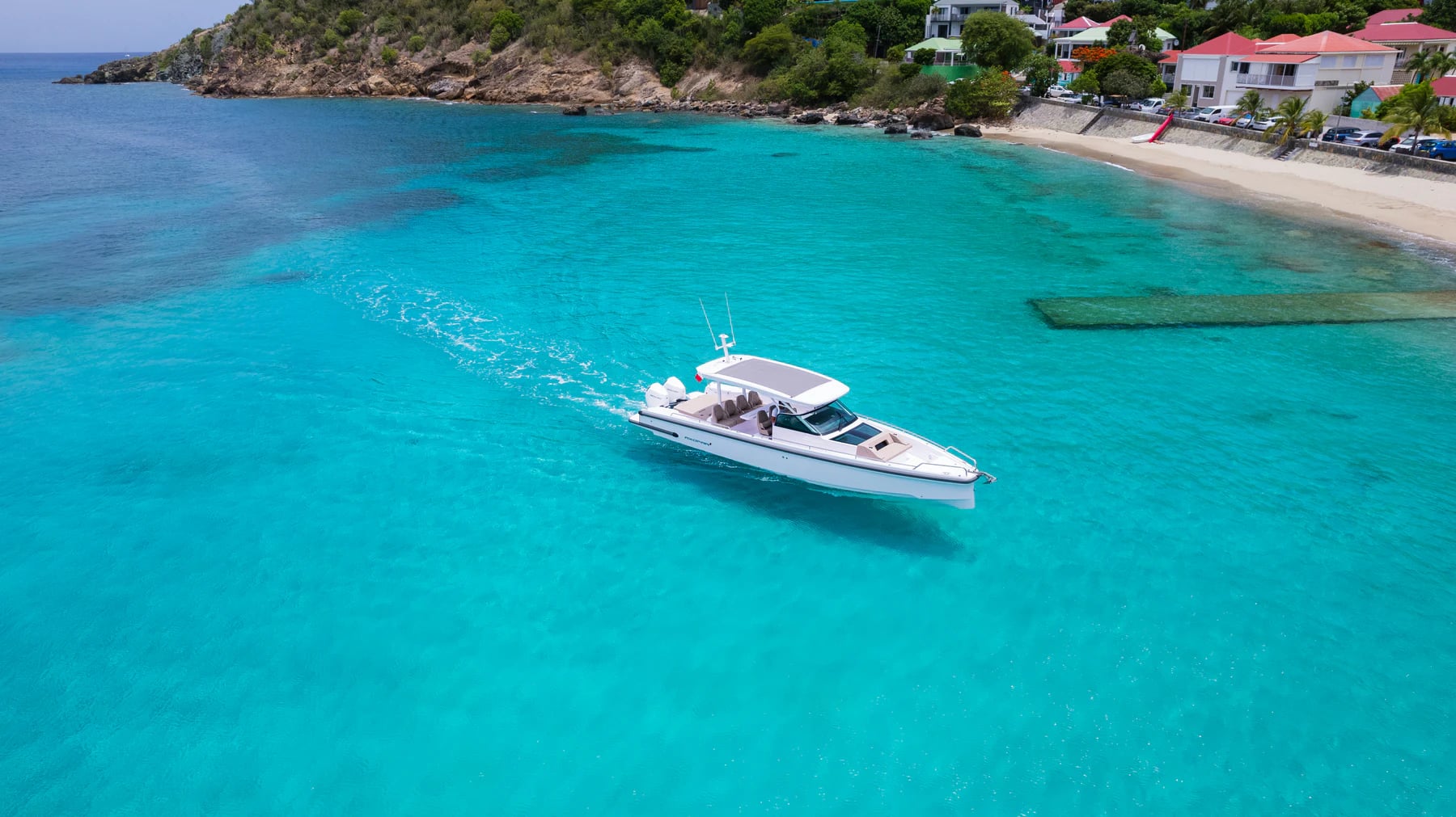Private boat crossing a turquoise bay