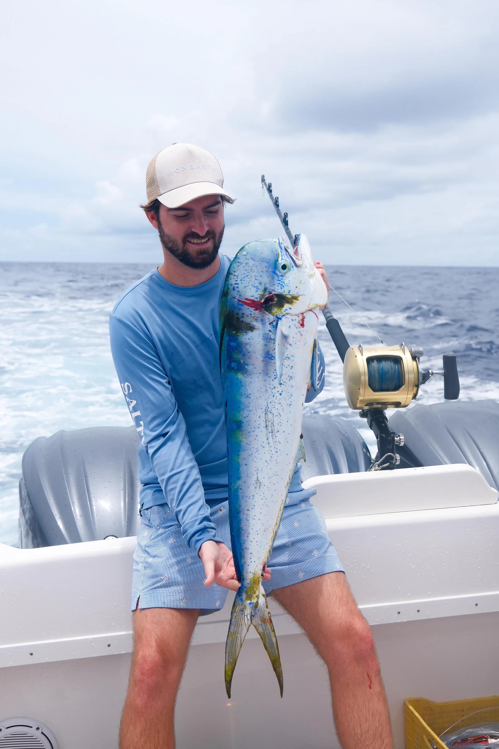 Pêcheur tenant un mahi-mahi à bord du bateau